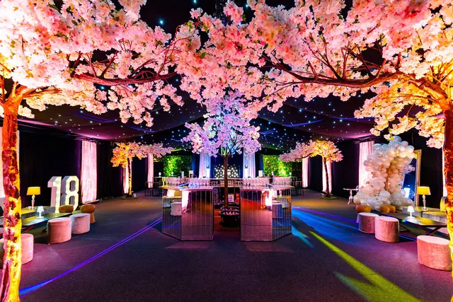 Party room decorated with a canopy of pink blossoms and lounge seating