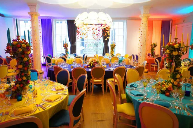 Wedding reception with round tables, bright flowers and a chandelier